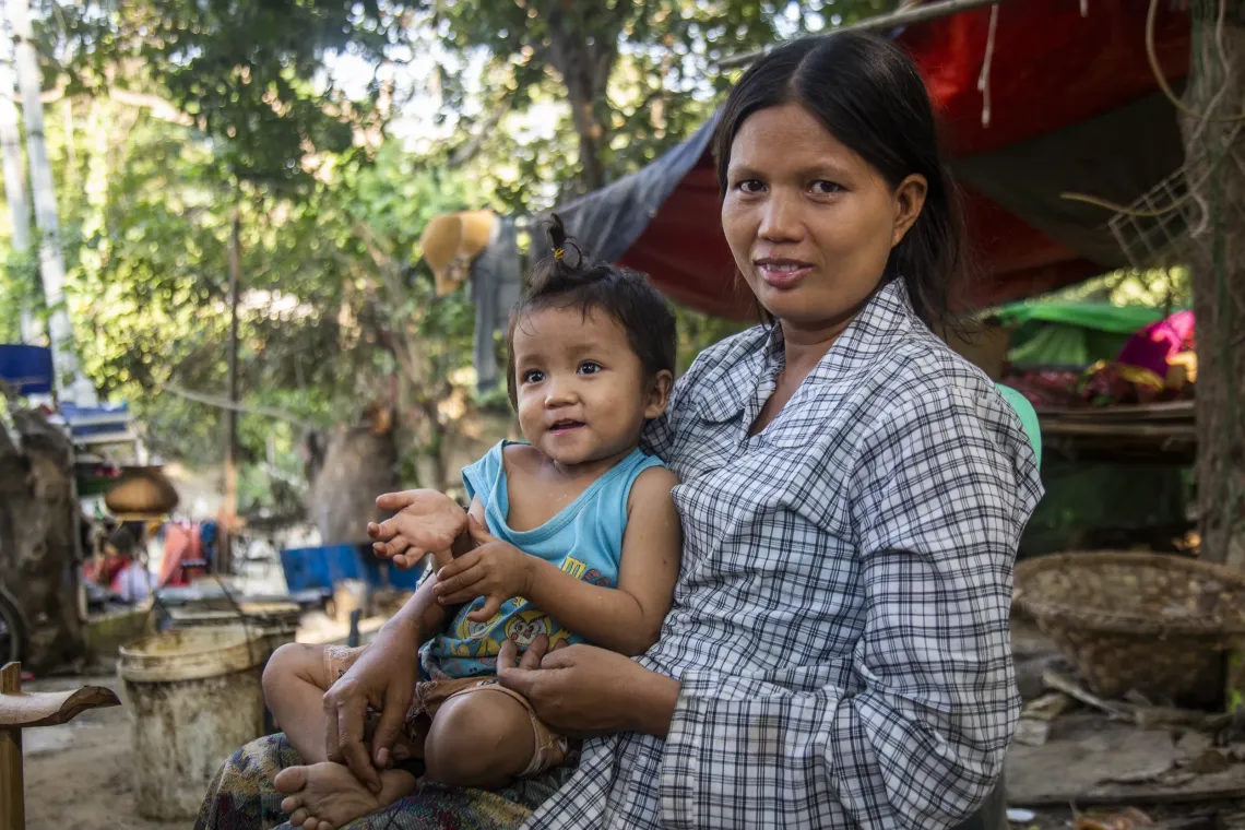 Ma Thet holds her young son, Kaung Kaung, in their community in Mandalay as he continues his recovery.