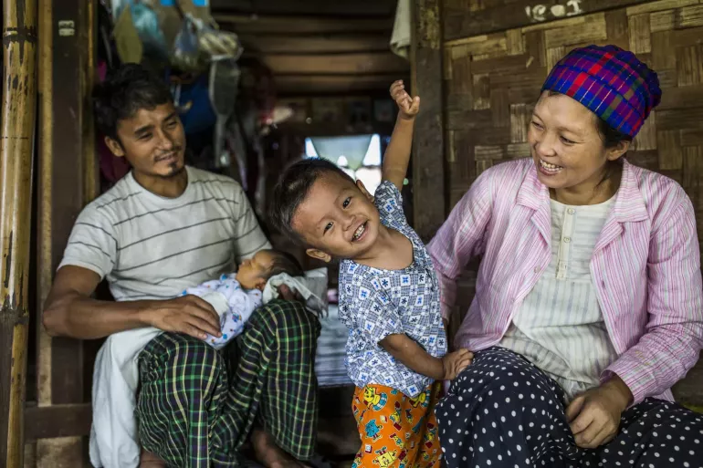 An ethnic Kachin family pictured sitting outside their family's shelter-room, at an IDP camp in Waingmaw, Kachin State, Myanmar. 