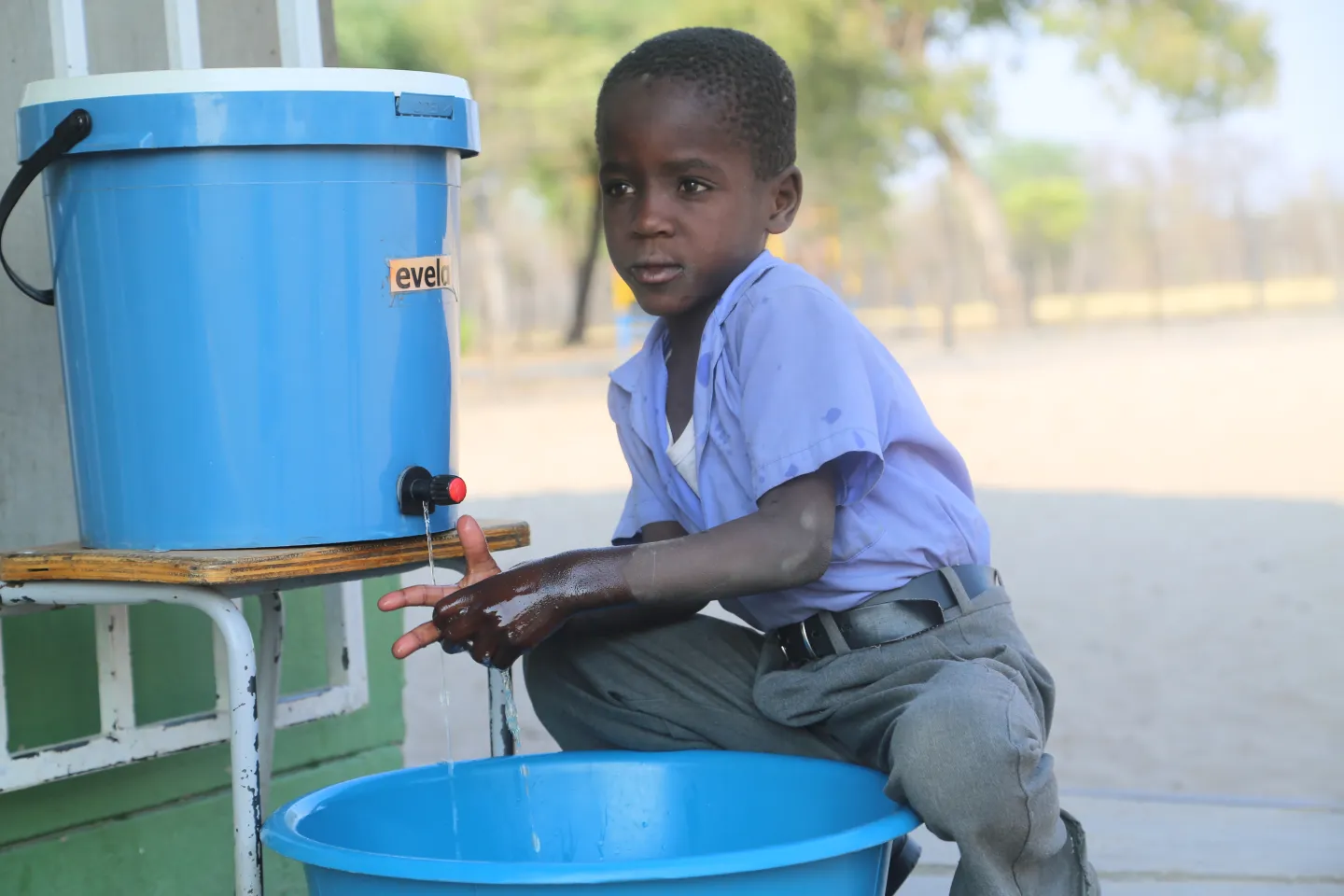 young boy child washing his hands at school