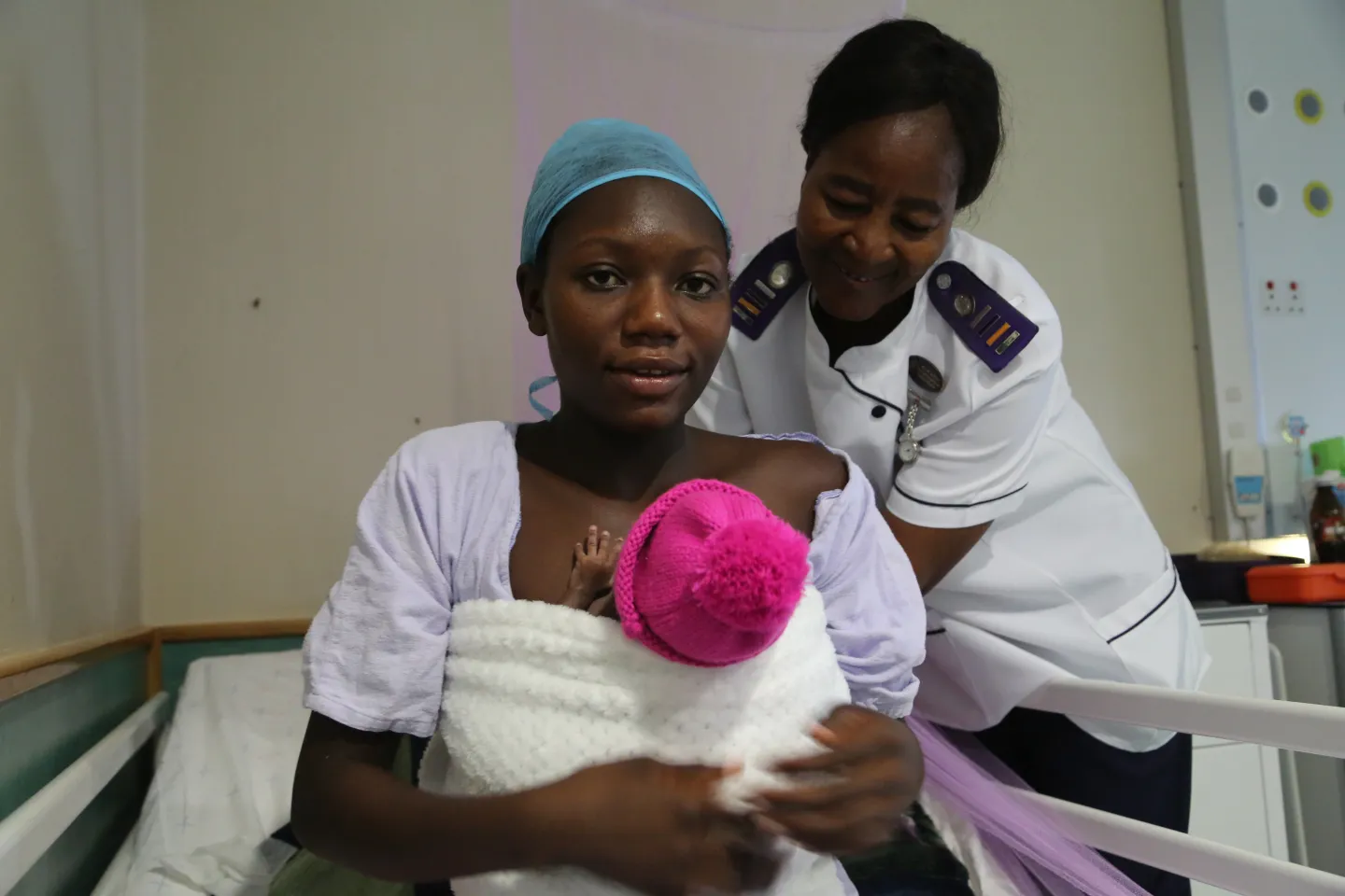 mother and newborn helped by nurse with kangaroo mother care