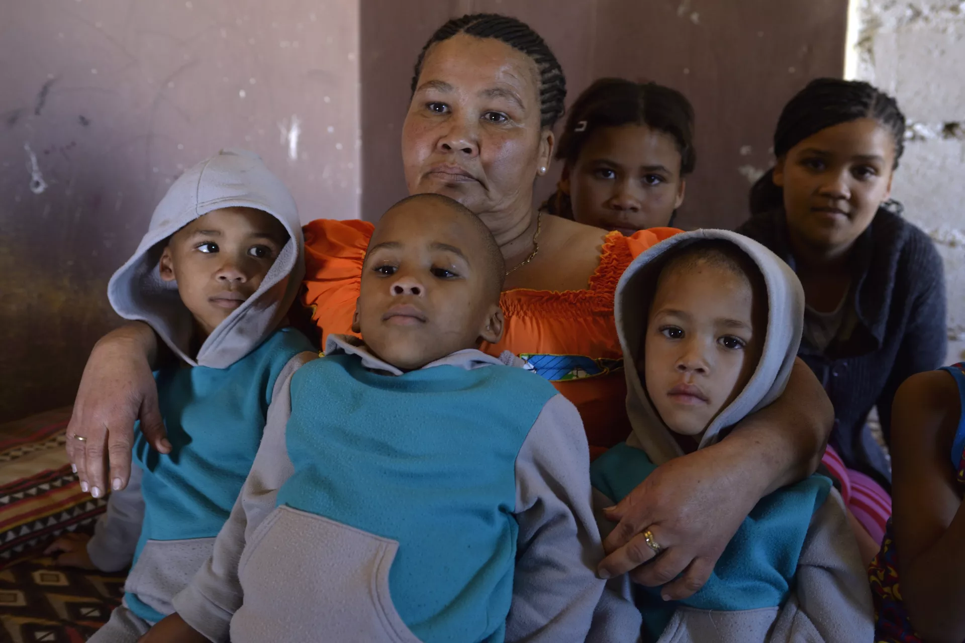 Mother with her 5 children sitting on a bed