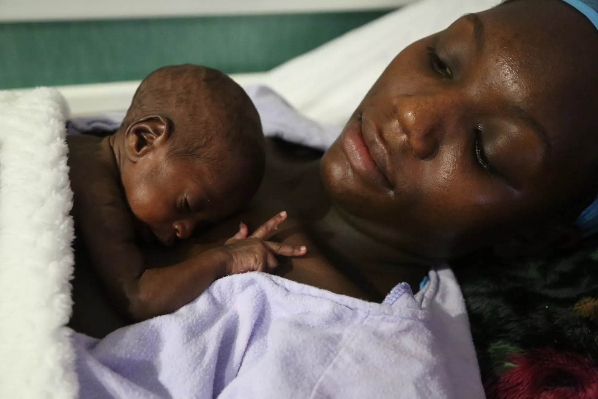 mother practicing kangaroo mother care with newborn