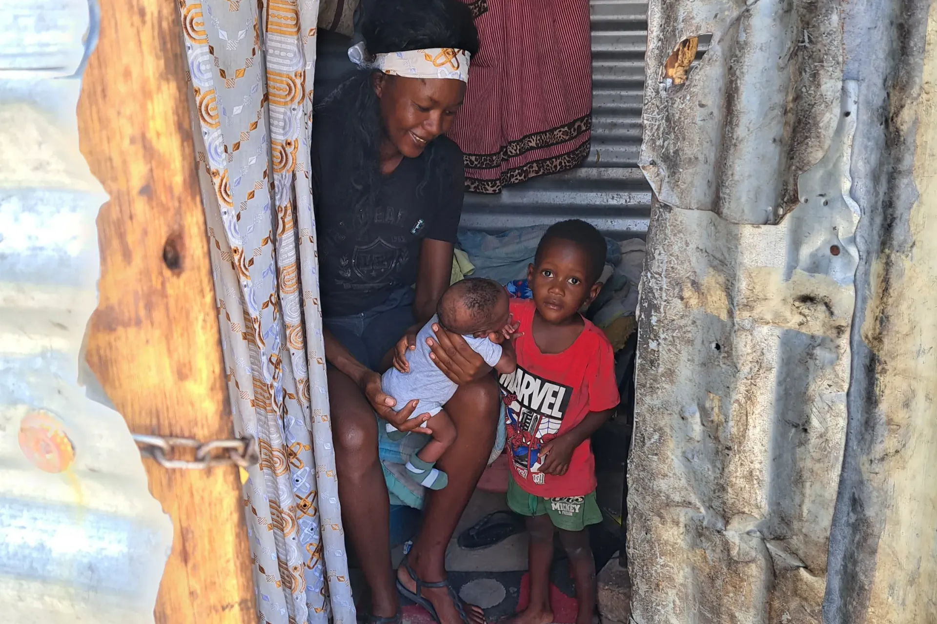 Mother sitting with her baby and toddler in a house