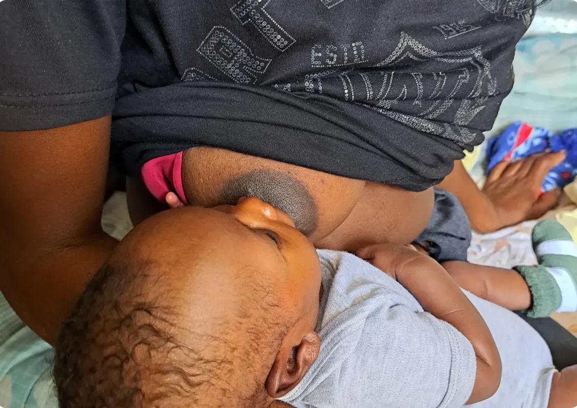 baby breasfeeding on his mothers lap