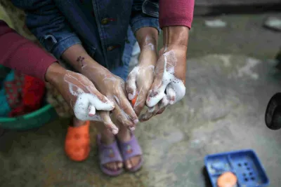 This image shows two pairs of hands washing with soap