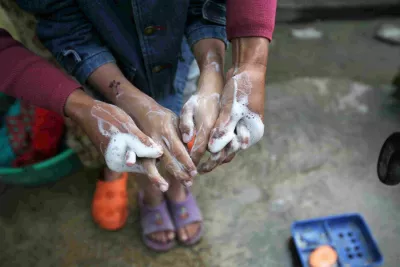 This image shows two pairs of hands washing with soap