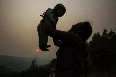 This image shows a silhouette of a mother raising her child up