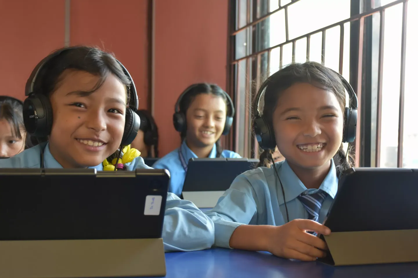 Two girl students happily using tablets for their study 