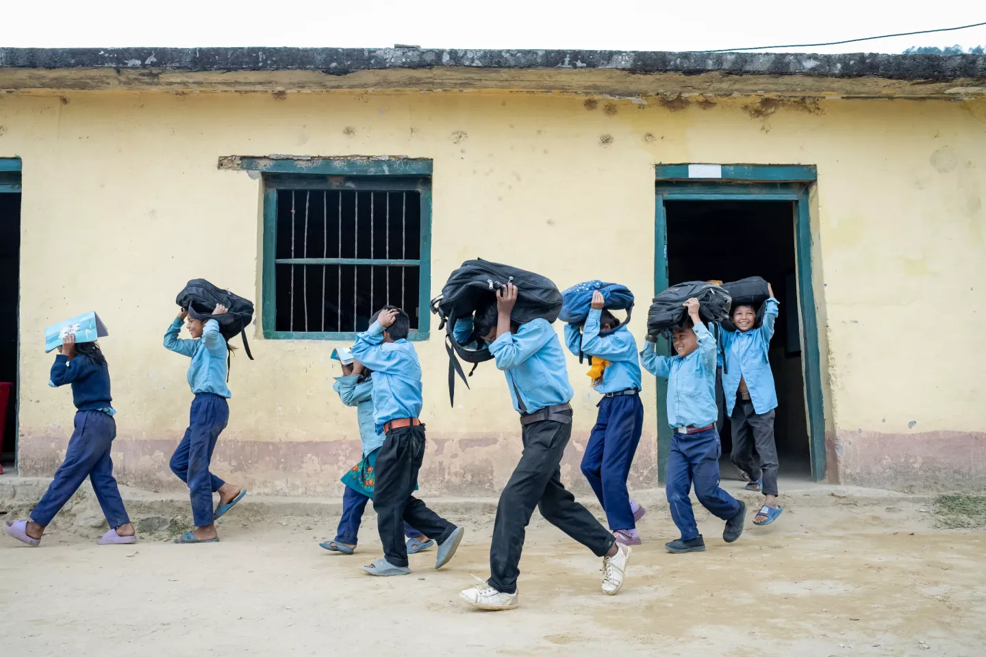 Group of students with school bag over their head practicing school safety during diesters  