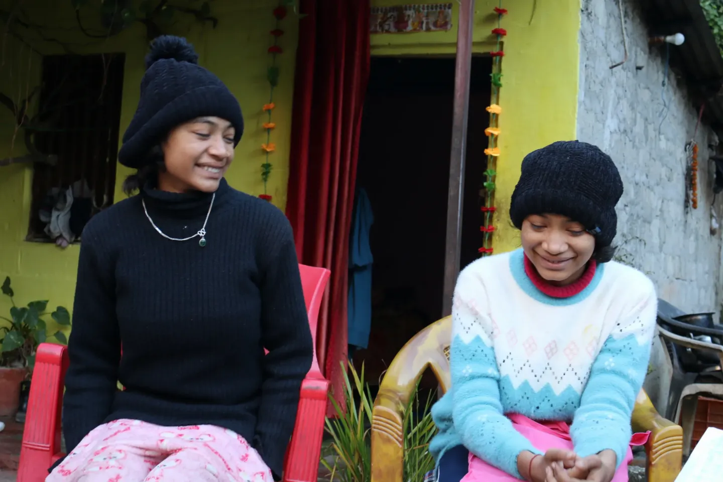 A group photo of twin sisters Tamanna and Tanisha sitting on a chair
