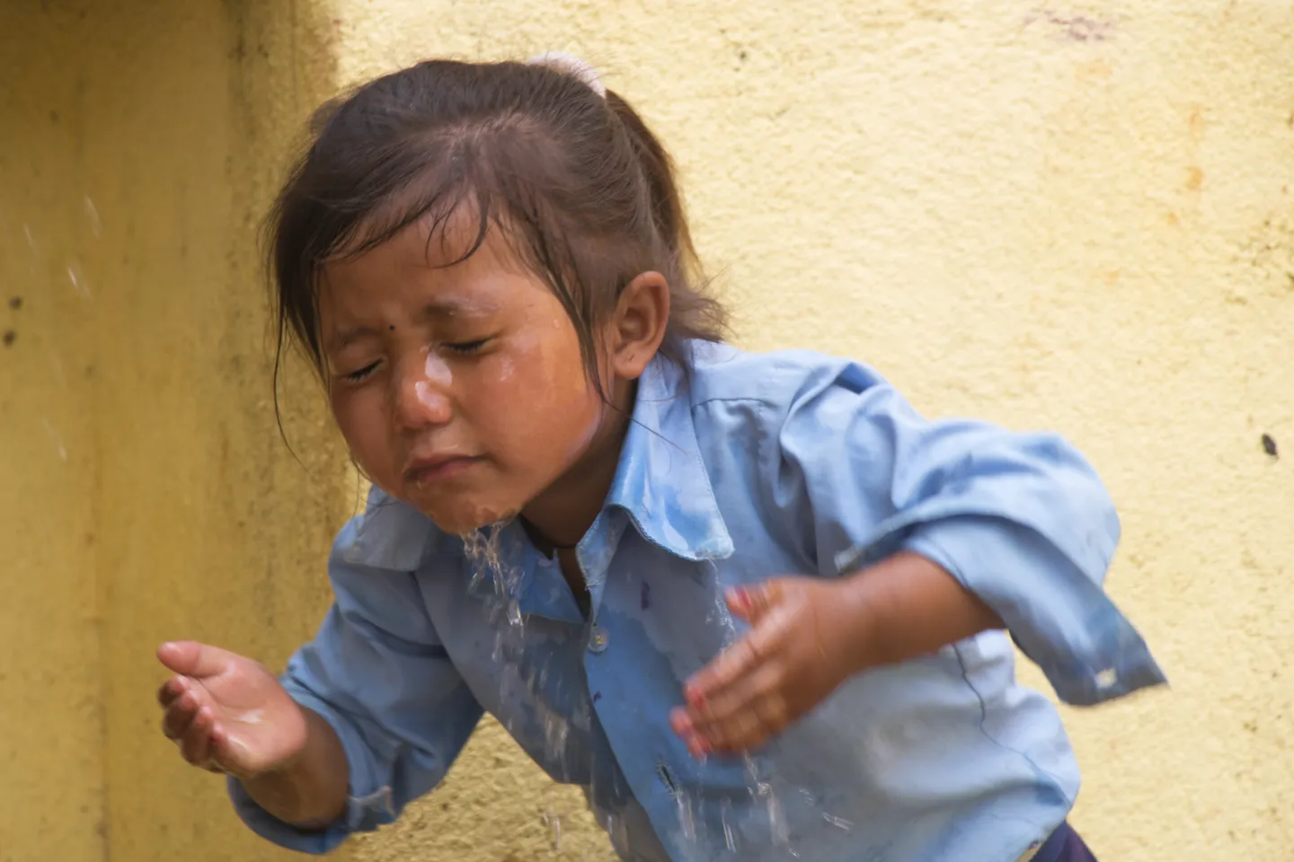A student washes her face using her school&rsquo;s water supplies facilities