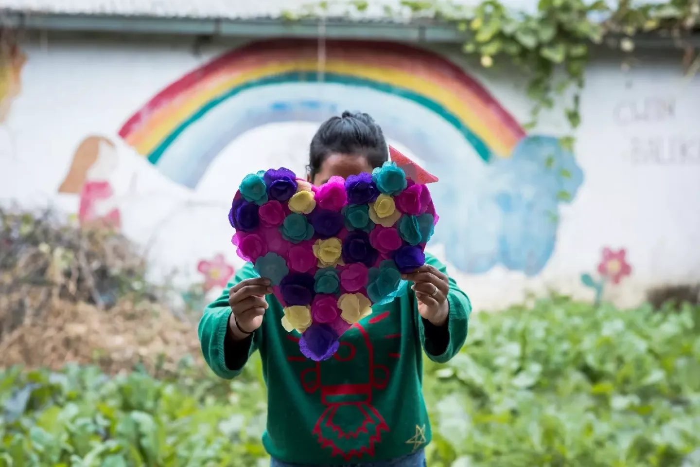 A girl holding heart shaped paper flower