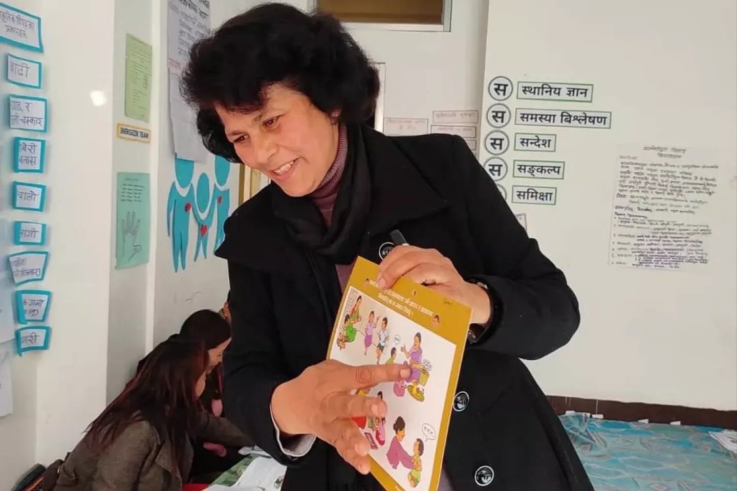 A woman pointing at the picture of the book 