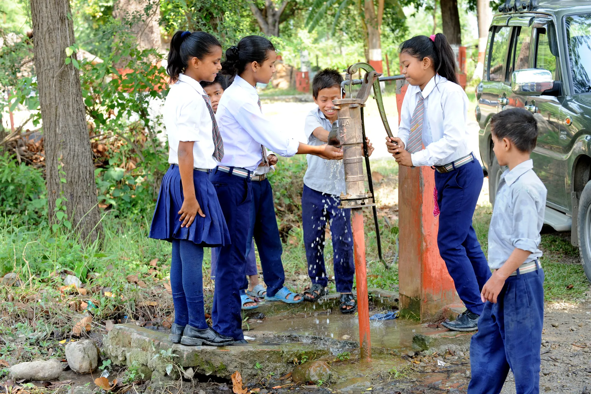 School girls pumping water 