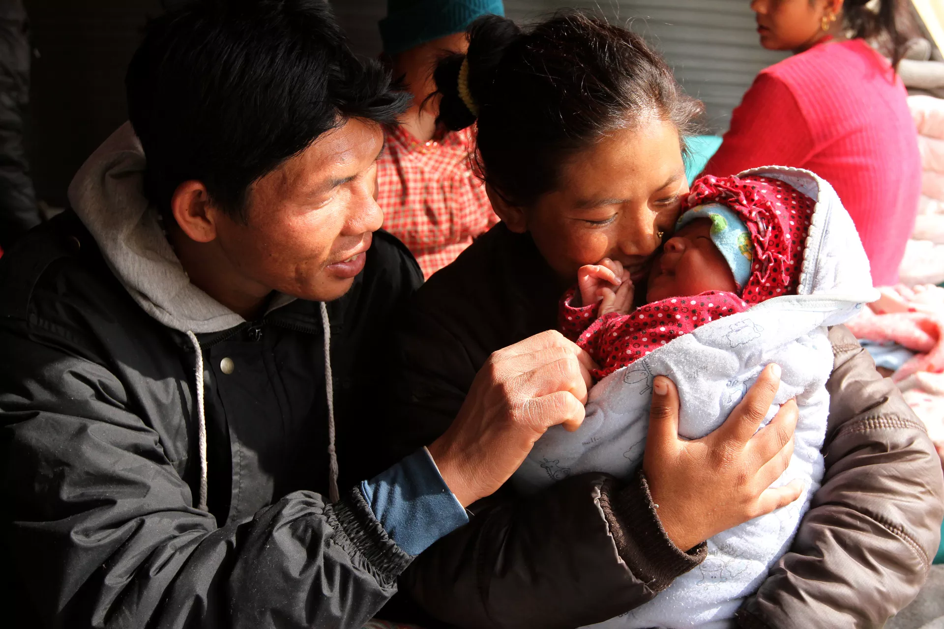 This image shows a father and a mother playing with their young child