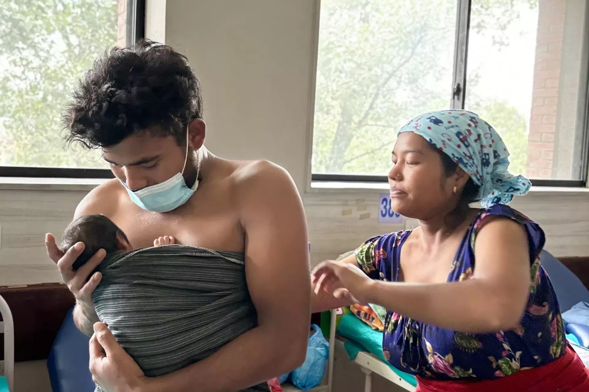 Prejina Chaudhary (right) helps her husband Ajay (left) to practice Kangaroo Mother Care with their newborn son at the Paropakar Maternity and Women&rsquo;s Hospital in Kathmandu. 