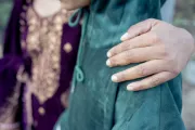 a woman with her hand on her child's shoulder