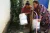 Women use UNICEF buckets received through emergency flood response supplies to collect water