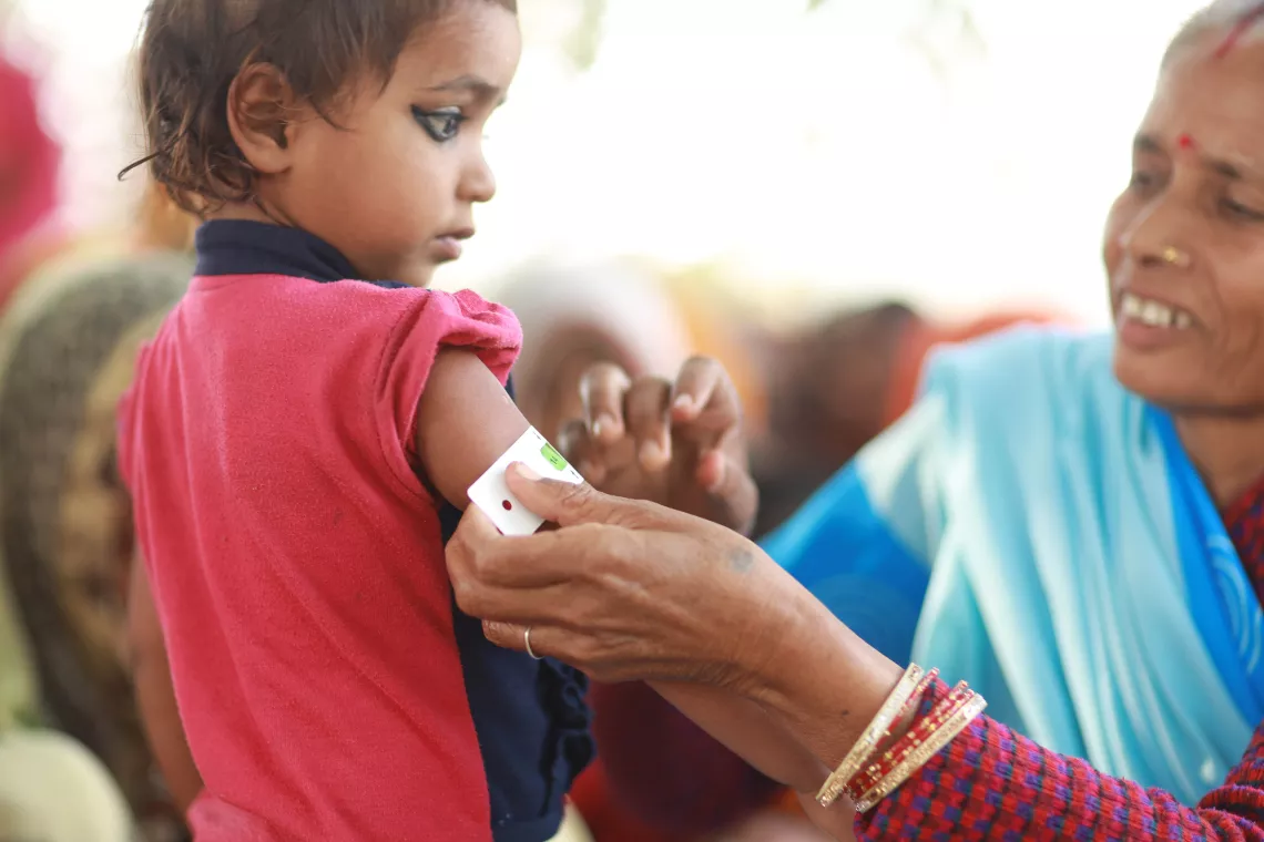 a child getting measured with a MUAC tape