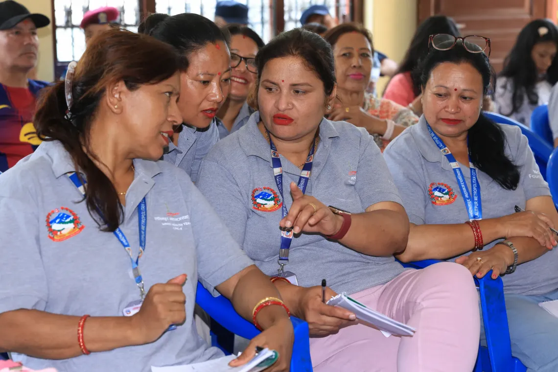 Bimala (centre) talking to her fellow FCHVs during the community-based surveillance orientation organized by the local government and UNICEF with support from the Pandemic Fund . 