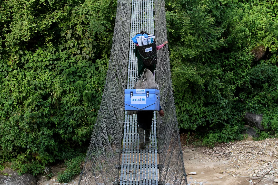 Porters carry vaccination supplies