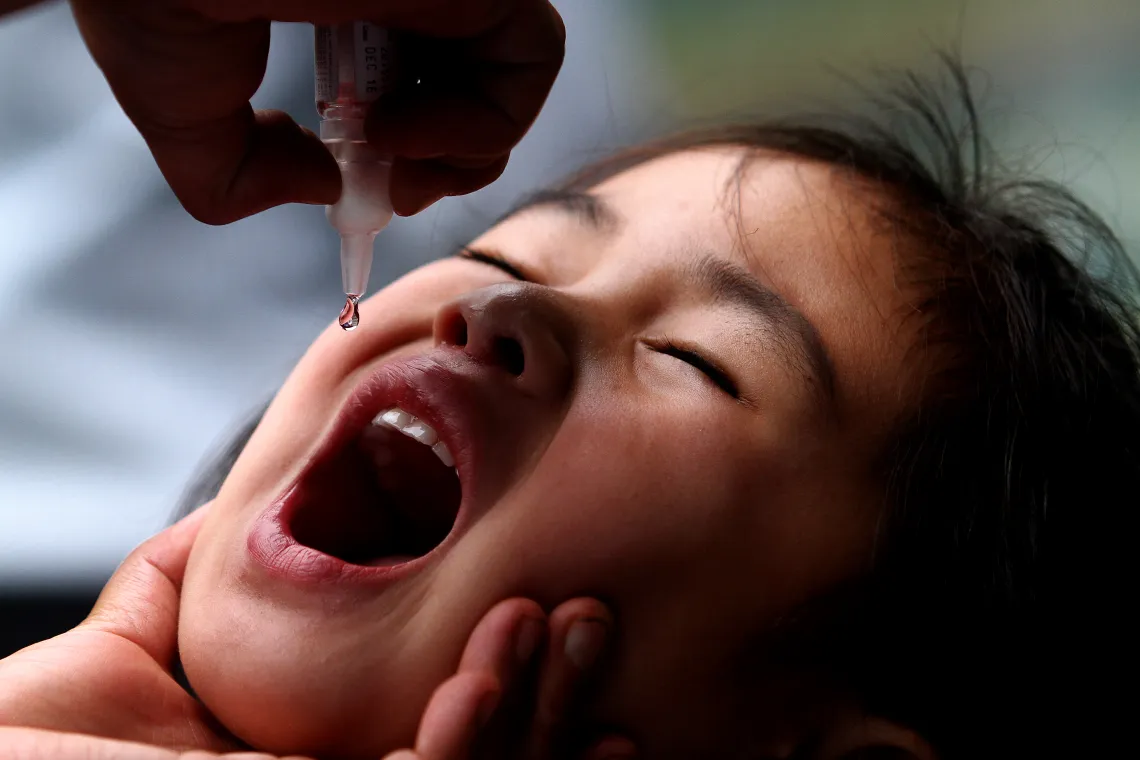 A girl getting polio drops