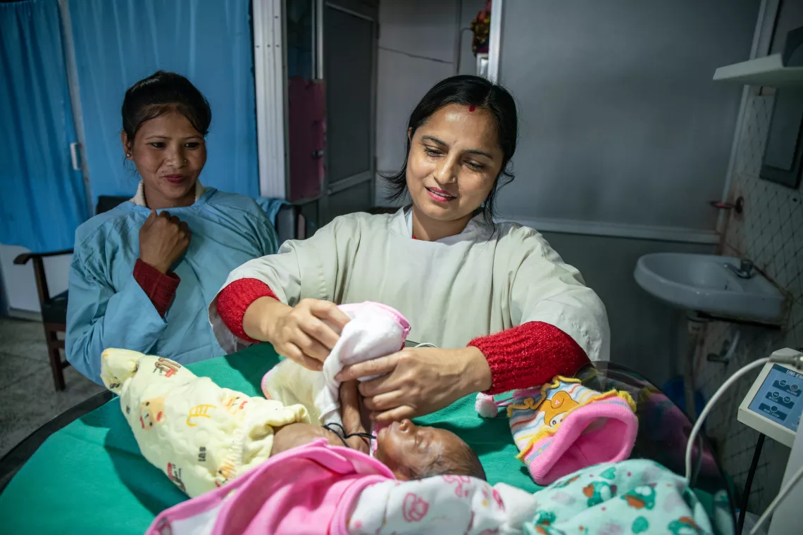 Sabina with the midwife who helped her deliver her baby during a check-up at the hospital.  