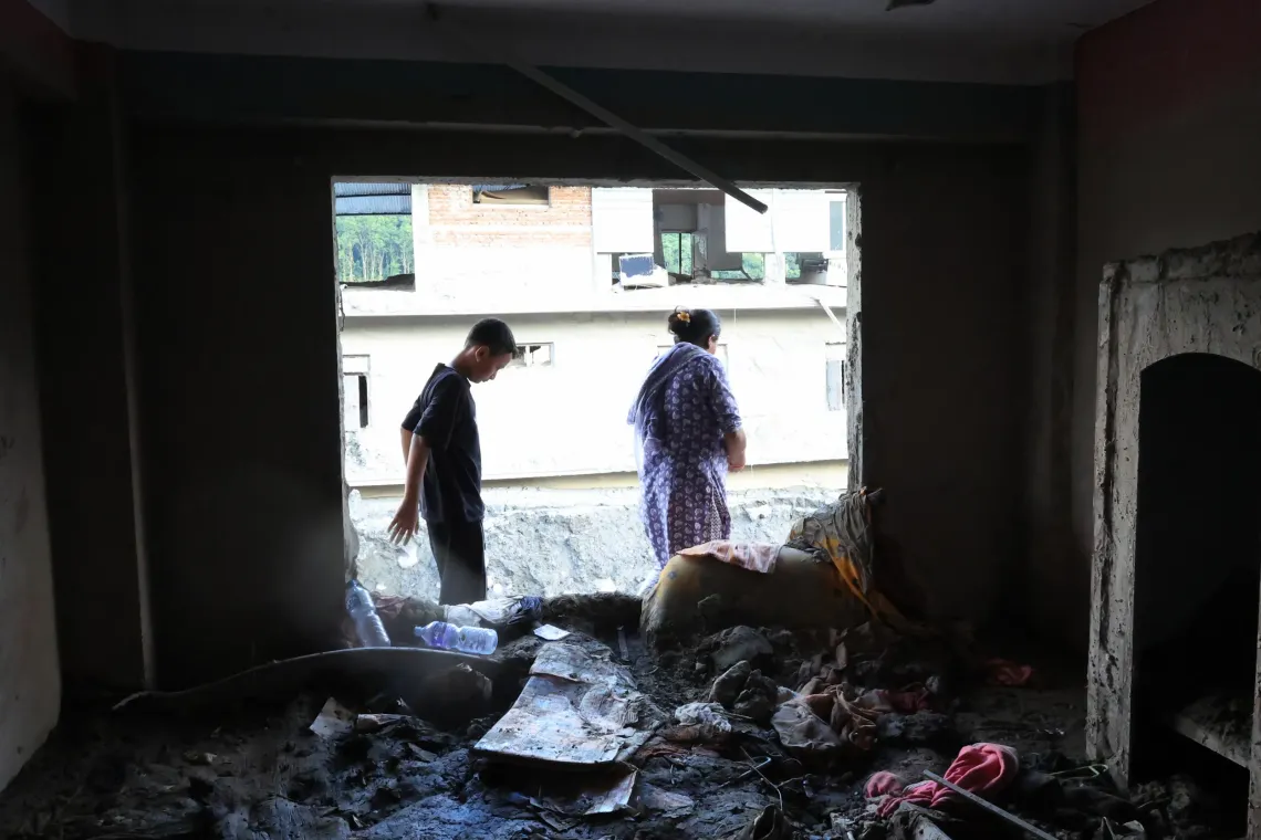 On 21 September 2026, Sita and her son Susin look through the remains of their home in Nuwakot,