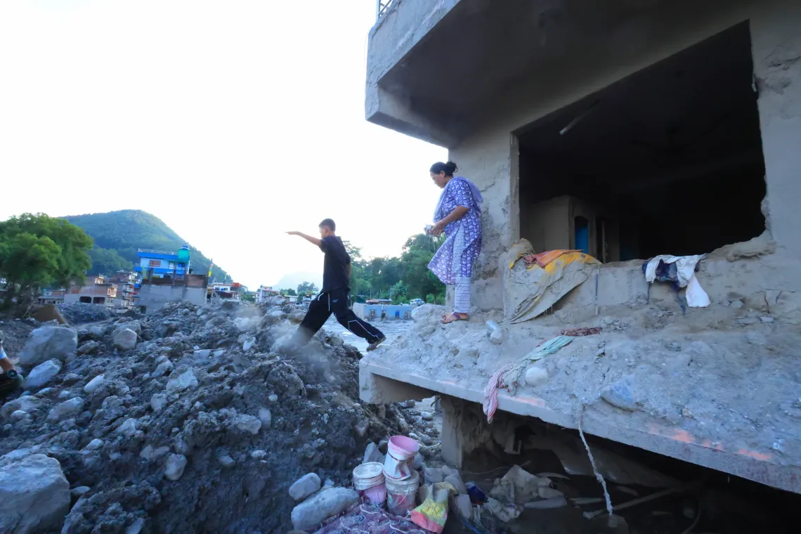 On 21 September 2026, Sita and her son Susin look through the remains of their home in Nuwakot, Nepal, searching for belongings.