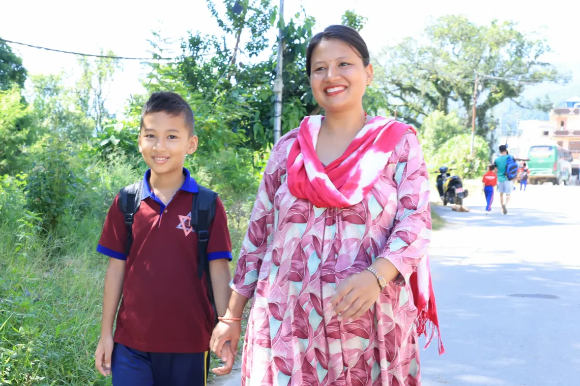 On 22 September 2026, Swastik, 12, and his mother, Sailaja, a primary teacher at Tribhuvan Trishuli Secondary School, walk to a UNICEF-supported temporary learning centre at the school in Nuwakot, Nepal. 