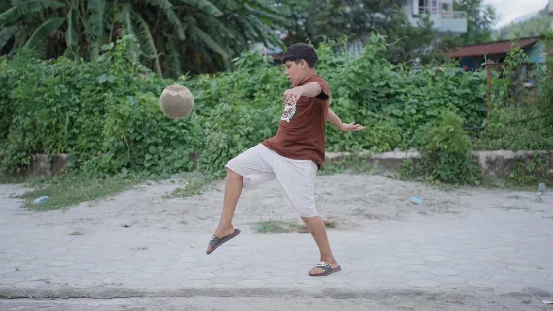 Swostik plays football at the temporary shelter