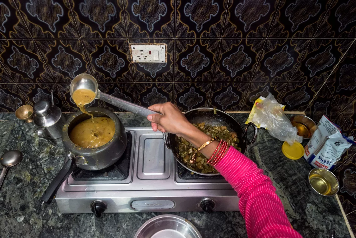 A view of hand over a stove, cooking