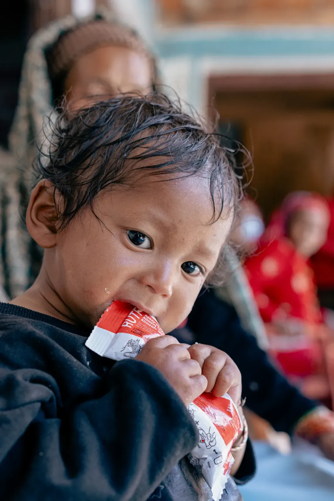 At the Tripurasundari Health Post in Dolpa District, 21-month old Nirajan Ukheda being fed Ready-to-Use Therapeutic Food (RUTF) by his mother Lal Kumari under the watchful eye of Female Community Health Volunteer Hans Kumari. The RUTF - provided by the US Government to Nepal through UNICEF - is a life-saving nutritional supply for treating children with severe acute malnutrition.