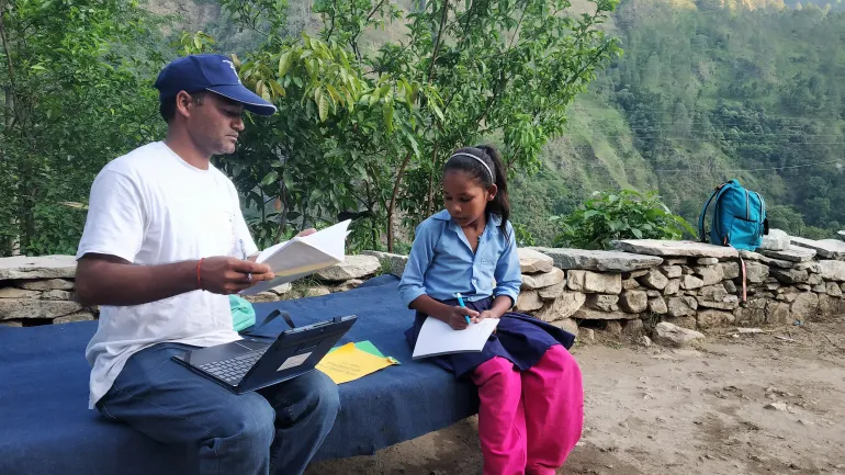 This image shows MICS enumerator Mahesh Bikram Bohara conducting a survey with girl child Mamita Pari in Bajura District in Nepal&rsquo;s far-west