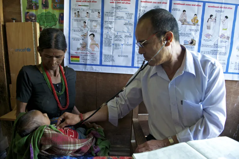 A male auxiliary nurse diagnoses a young child in an Outpatient Therapeutic Programme (OTP) at a primary health care centre in Bayalpata in Achham District of Far-Western Region of Nepal.