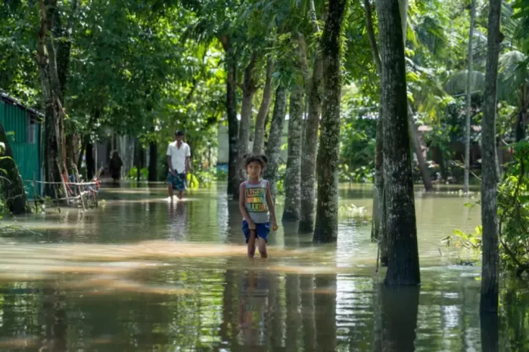 a child standing in a flooded road