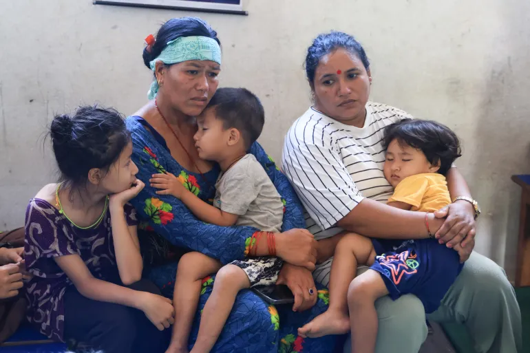A family shelters together in a school, after floods destroyed their homes in Nepal in August 2026.