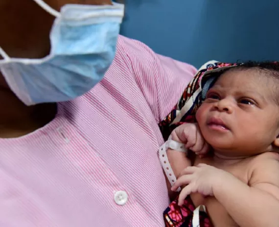 This image shows a healthworker holding a child