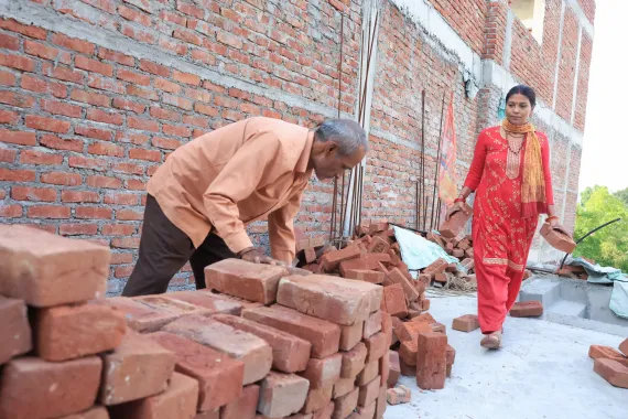 Lila and Uttam collecting bricks in one place