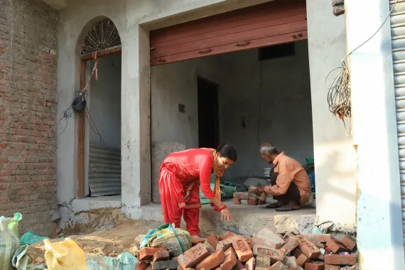 Lila and Uttam collecting bricks inside their house for construction
