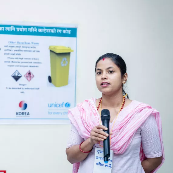 A woman speaking with mic in her hand.