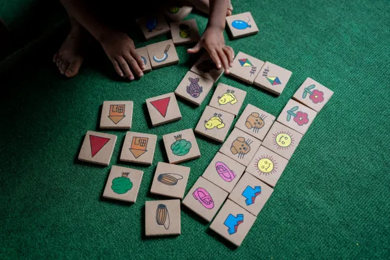 A child plays with blocks on the floor of an ECED classroom