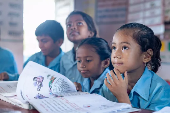 Students are learning in the classroom with books open in front of them