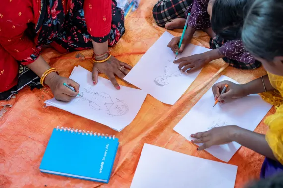 A closeup picture of SAGE participants drawing on a paper
