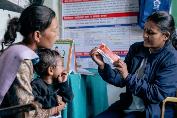 Auxiliary nurse midwife at the Tripurasundari Health Post Srijana Rokaya counselling young mother Lal Kumari Ukheda whose one-year-old son, Nirajan, has been diagnosed with severe acute malnutrition. 