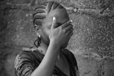 A girl covers her face.