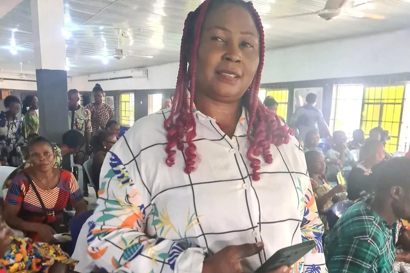 A woman standing with a phone in her hand.