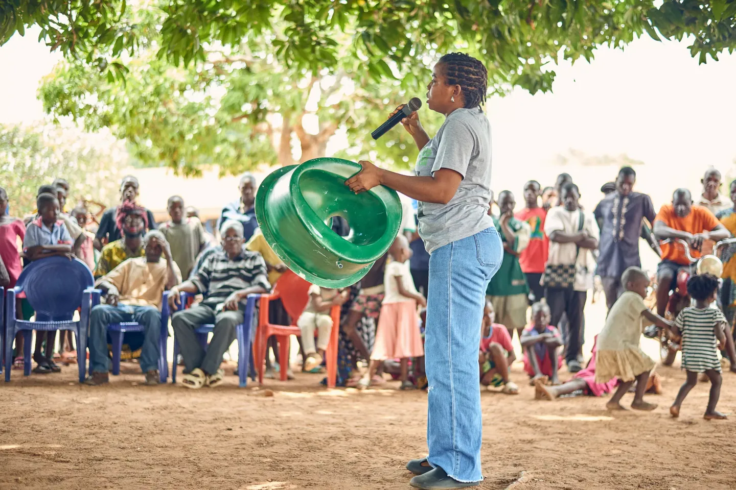 A woman holding a Sato toilet to sensitize people.