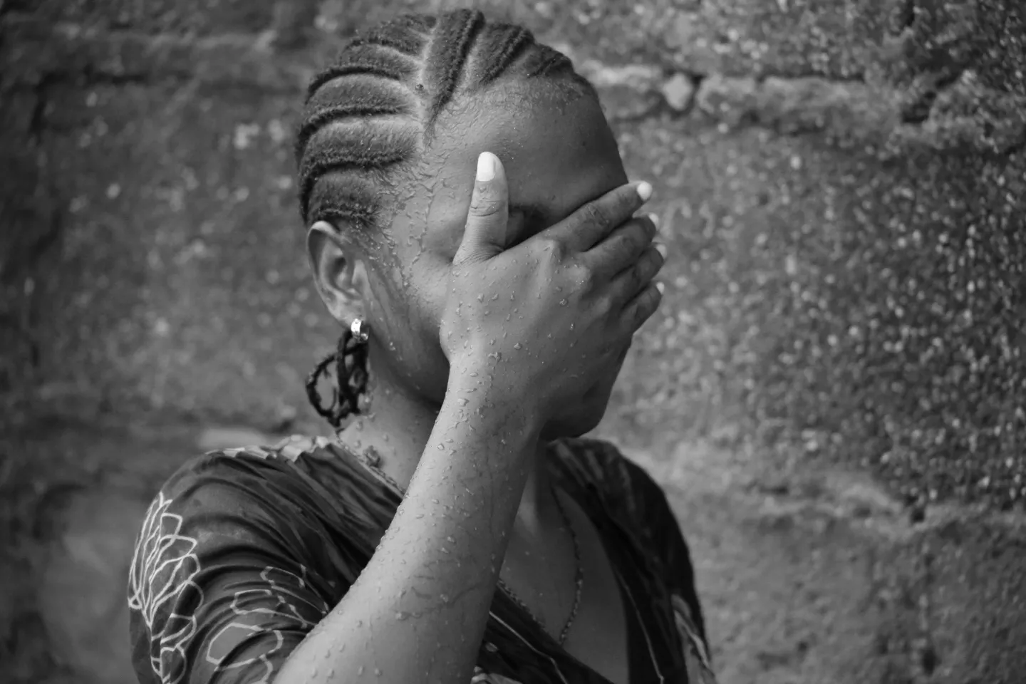 A girl covers her face.
