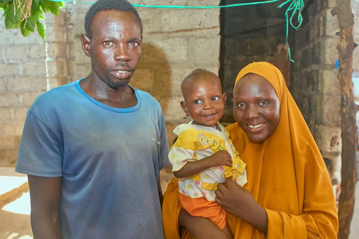 One-year-old Ummusalama Rabiu poses with her parents, Rabiu and Shamsiyya Isiyaku, 30, inside their home in Bayan Hayin Gada Ward, Jibia Local Government Area, Katsina State, Nigeria.